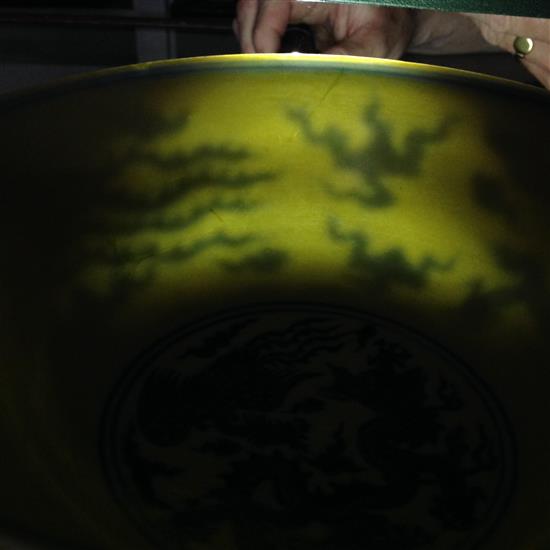 A Chinese yellow ground dragon and phoenix bowl, Xuande six character mark and possibly of the period, 19.5cm, museum restoration, sc